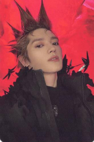 Photocard of Taeyong from NCT wearing a feathery black jacket with spiked hair, looking down at the camera