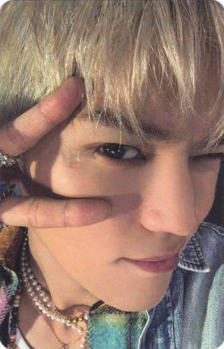 Close up photocard of Taeyong making a peace sign by his eye and winking