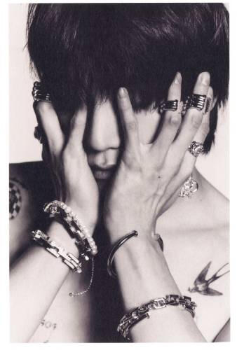 A card of Taeyong from NCT in black and white gripping his face
