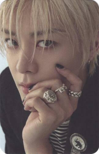 Photocard of Yuta resting his face on his hand and looking into the camera