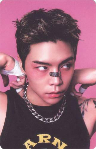Photocard of Johnny with cuts on his face and wrapped hands, glaring to the side