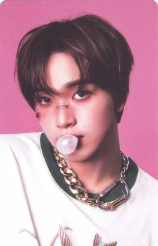Photocard of Haechan with cuts on his face blowing a bubble with gum