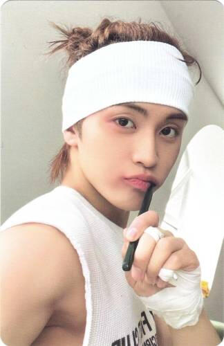 Photocard of Mark pretending to brush his teeth with a bandage wrapped around his head