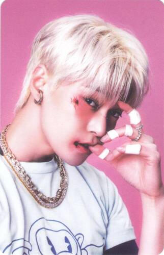 Photocard of Doyoung with cuts on his face and holding his fingers by his mouth