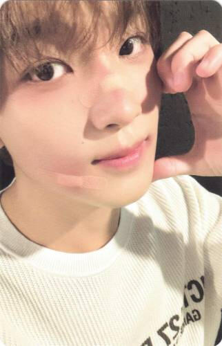 Photocard of Haechan making a half heart against his cheek