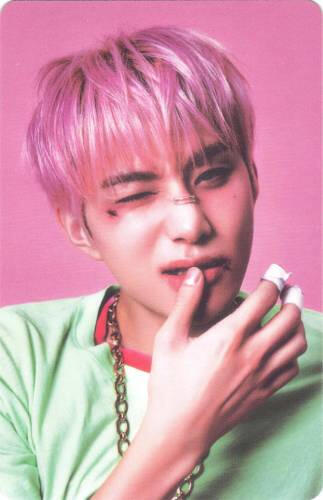 Photocard of Jungwoo with cuts on his face wincing and wiping his lip