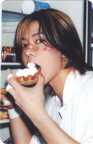 Photocard of Yuta with bandaids on his face eating a pastry out of the fridge