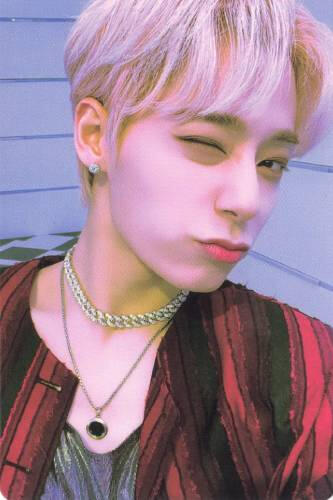 Photocard of Hwanwoong wearing a red and black flannel and blue shirt, turned to the side and winking