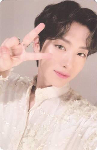 Photocard of Xion in an embellished white shirt making a peace sign
