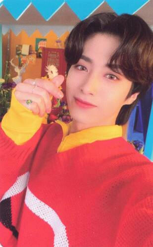 Photocard of Xion wearing a red sweater and holding up a finger heart