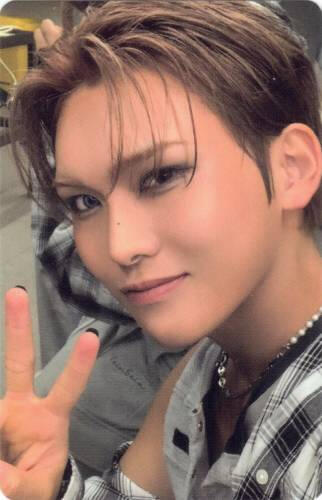 Photocard of Hyun smiling and making a peace sign