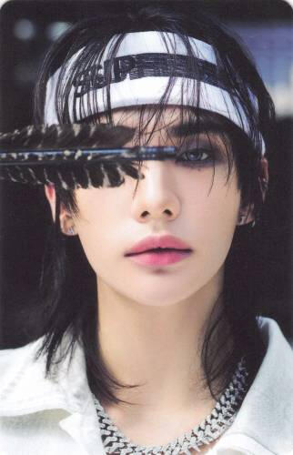 Photocard of Hyunjin holding the feather of an arrow in front of his eye