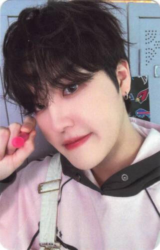 Photocard of Louis holding a pink crayon