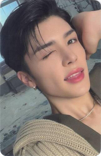 Photocard of Maki sticking his tongue out and holding his hand to his head